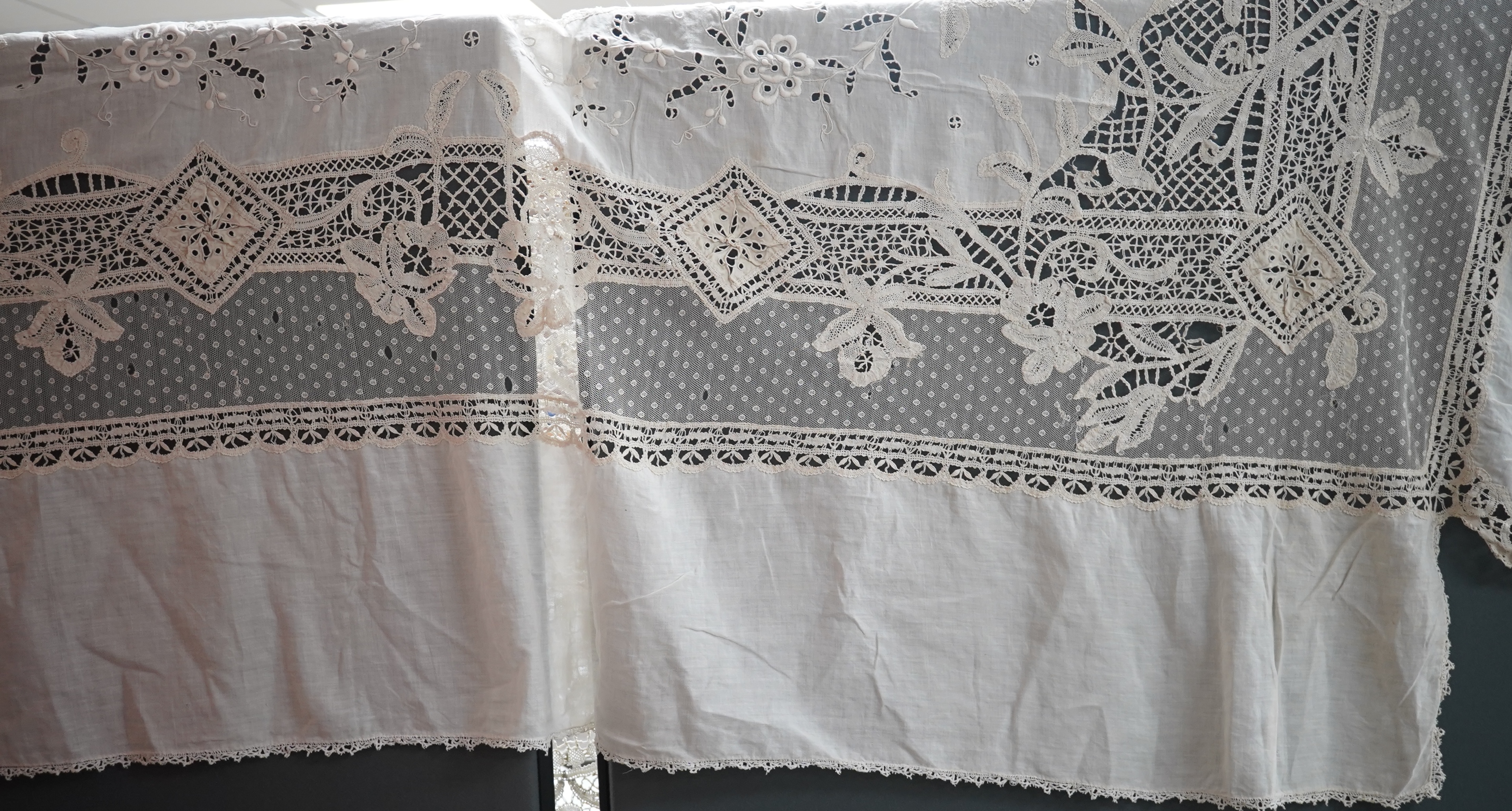 An ornate Edwardian bed cover, handmade from cut work anglaise panels, fine spot motif net and bobbin lace insertions, 228cm wide x 228 cm long. Condition - the spot motif net and fine lawn are damaged in places, the law